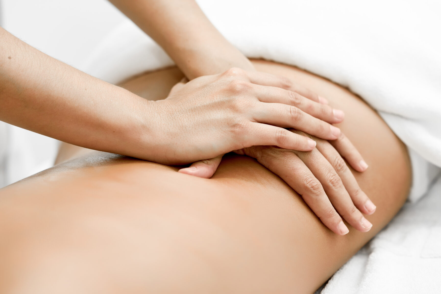 Nahaufnahme einer Person, die eine entspannende Rückenmassage auf einer Massageliege erhält.