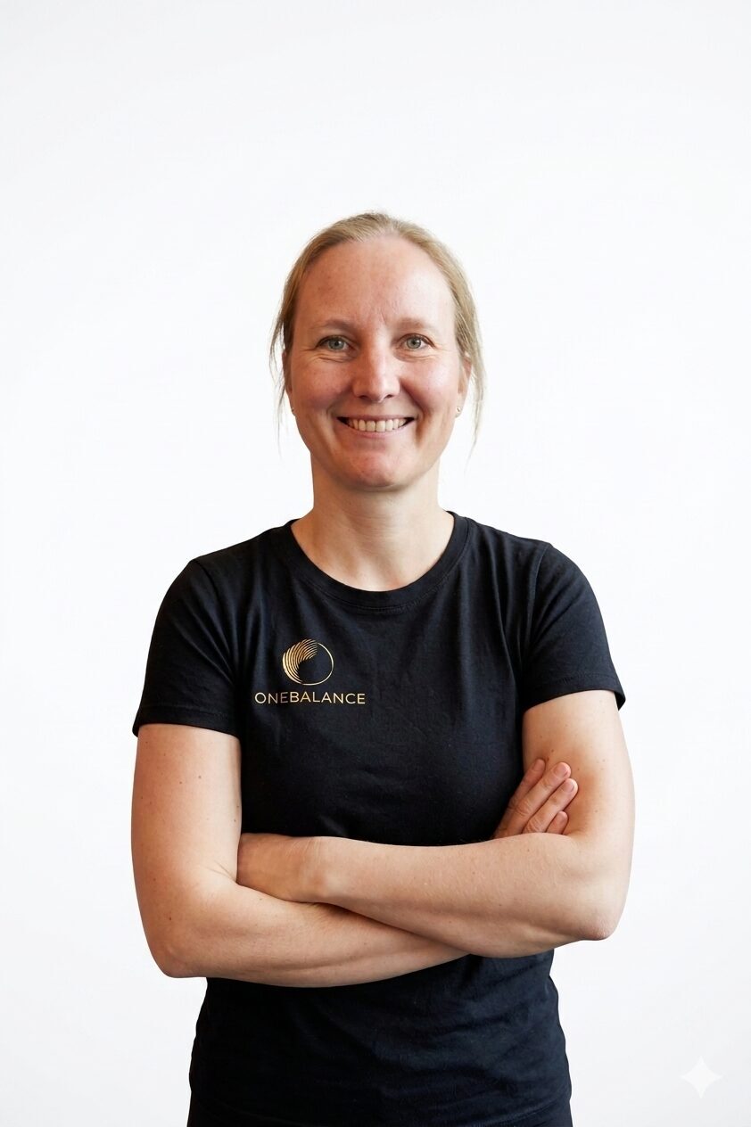 Porträt einer Physiotherapeutin in Karlsruhe mit verschränkten Armen vor hellem Hintergrund für Julia Bühler Physiotherapeutin in Karlsruhe