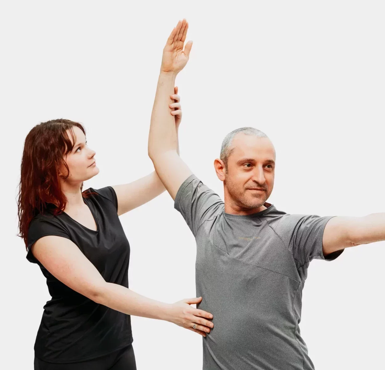 Physiotherapeutin führt manuelle Therapie in Karlsruhe durch und mobilisiert Schulter und Arm eines Patienten